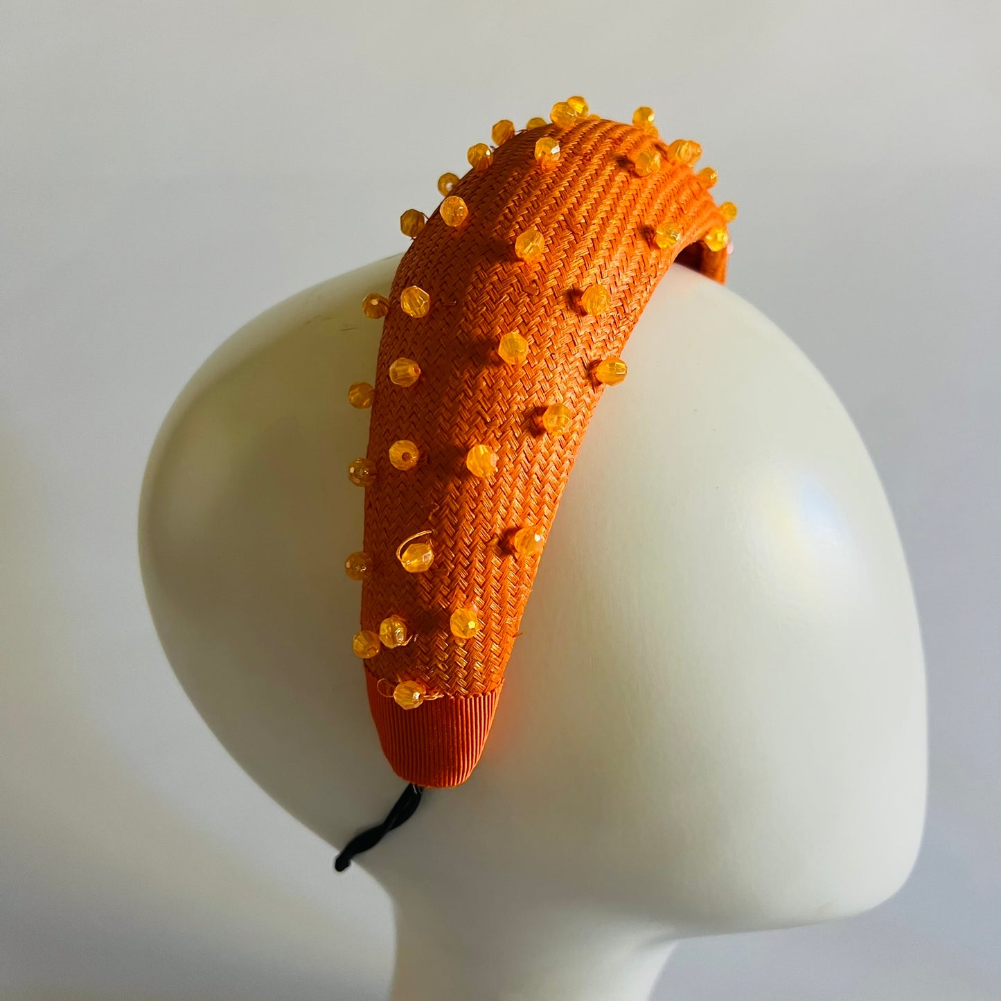 Orange padded headband finished with delicate bead trim