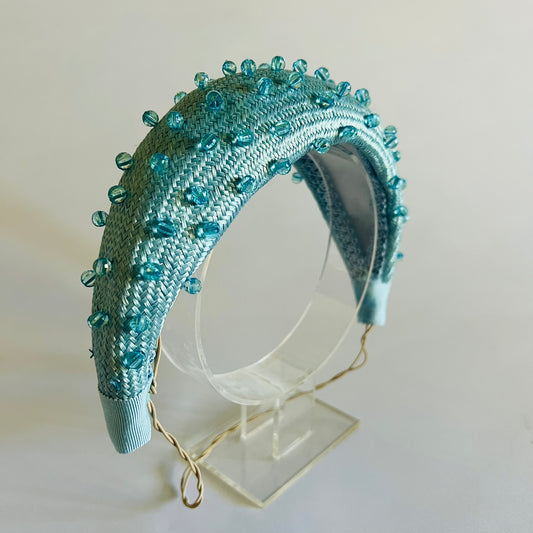  A pale blue padded headband finished with delicate bead trim. Stylish yet comfortable, it’s an easy way to elevate your look. Secured with elastic to the back of the head.