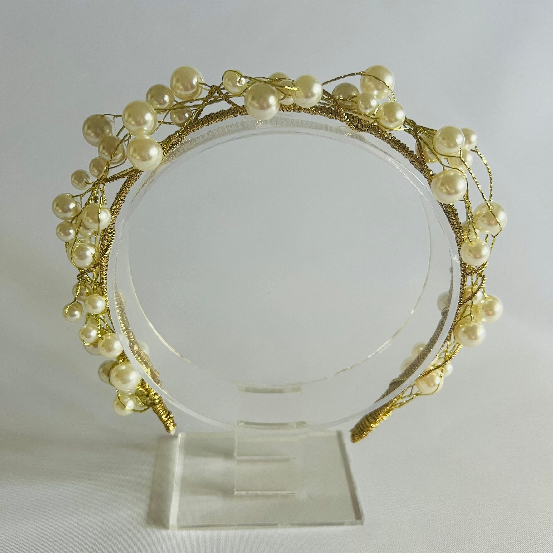 A chic headband adorned with clusters of pearl beads and touches of gold, creating a timeless and elegant look.