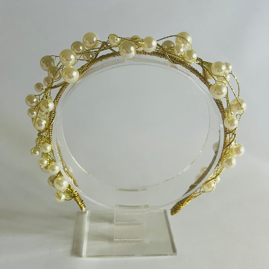 A chic headband adorned with clusters of pearl beads and touches of gold, creating a timeless and elegant look.